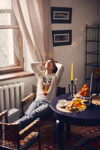 A beautiful woman in depression and with a sore head sits on a hotel chair. Front view.
