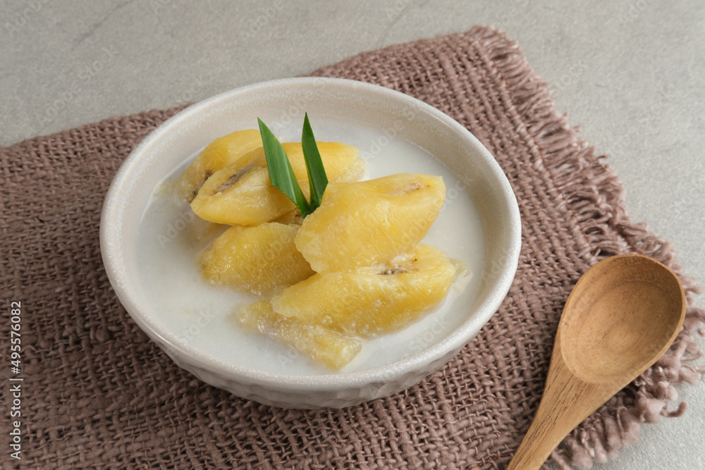 Kolak, Kolak Pisang is Indonesian traditional dessert, very popular during Ramadhan, made from banana with coconut milk, sugar and pandanus leaves. Served in white bowl on grey background, copy space. Kolak, Kolak Pisang is Indonesian traditional dessert, very popular during Ramadhan, made from banana with coconut milk, sugar and pandanus leaves. Served in white bowl on grey background, copy space.
