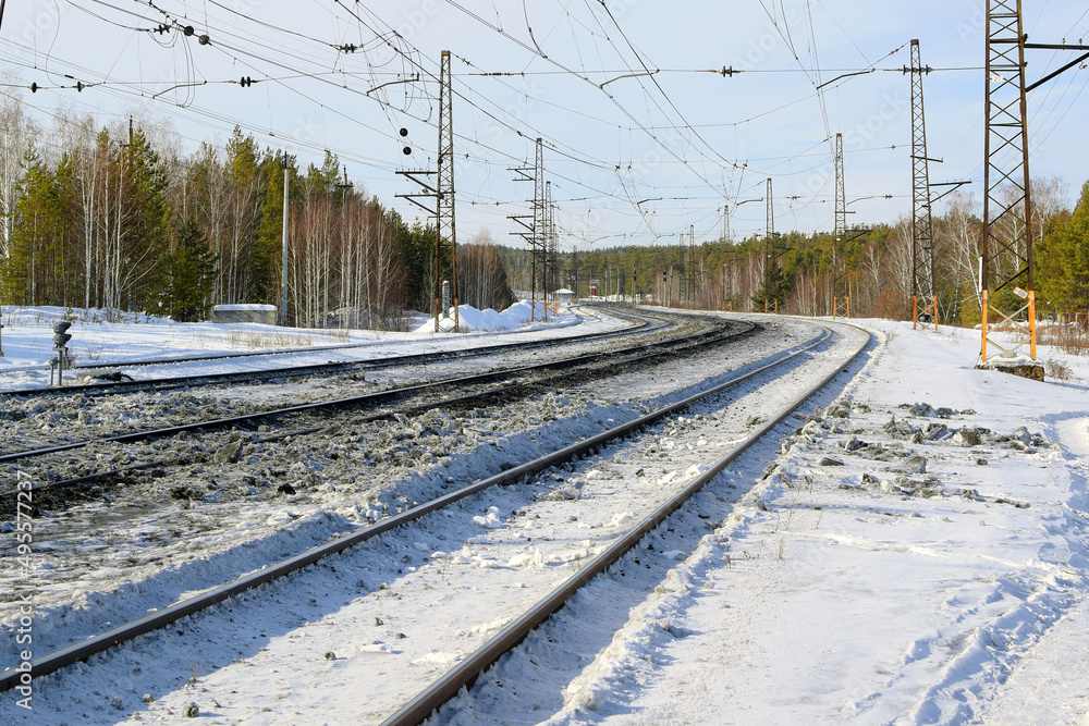 Fototapeta premium Railway winding tracks go into the distance beyond the horizon, winter landscape.