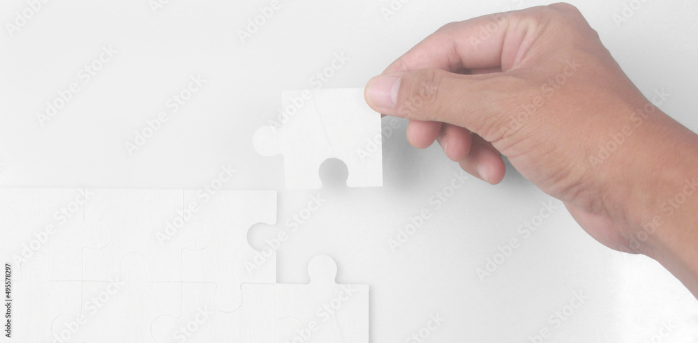 Connecting jigsaw puzzle in hand. Business solutions success and strategy concept Connecting jigsaw puzzle in hand. Business solutions success and strategy concept