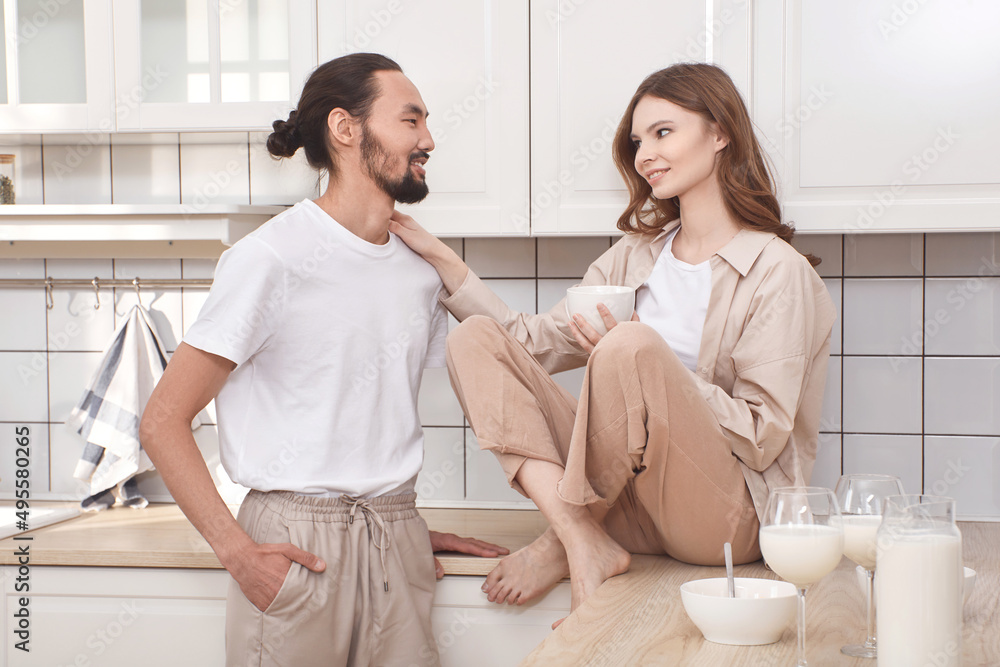 Couple in love having breakfast in the kitchen, multinationality Couple in love having breakfast in the kitchen, multinationality