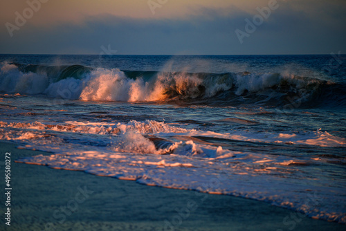 Sea waves background. Sunset with large yellow sun under the sea surface. Waves splashes.