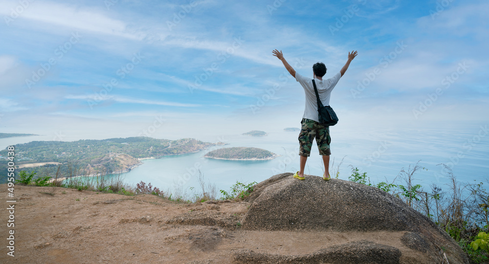 Alone happy man photographer or traveler standing and thinking something and see beautiful scenery landscape nature view on rock mountain in phuket thailand Alone happy man photographer or traveler standing and thinking something and see beautiful scenery landscape nature view on rock mountain in phuket thailand