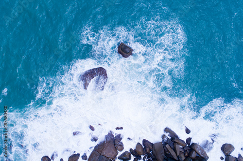 Aerial view Top down seashore big wave crashing on rock cliff Beautiful dark sea surface in sunny day summer background Amazing seascape top view seacoast at Phuket Thailand