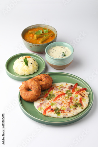 South Indian food like Uttapam, Wada, vada, Pongal, Sambar with chutneys, selective focus