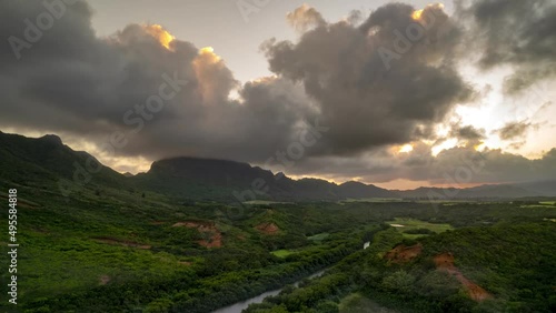 Beautiful sunset of clouds boiling across a golden sky, Kauai, Hawaii, Menehune Fishpond, aerial hyperlapse photo