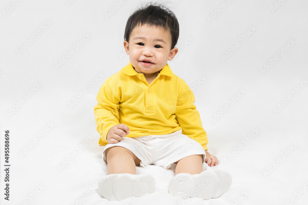 Asian cute baby boy about one year old in yellow shirt sitting and smile isolated on white Selective focus. Asian cute baby boy about one year old in yellow shirt sitting and smile isolated on white Selective focus.