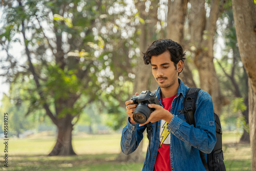 Canvas Print Young photographer checking photos in the camera