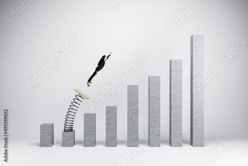Concept of business boost and growth. Superhero businesswoman flying off of springboard to business chart top.