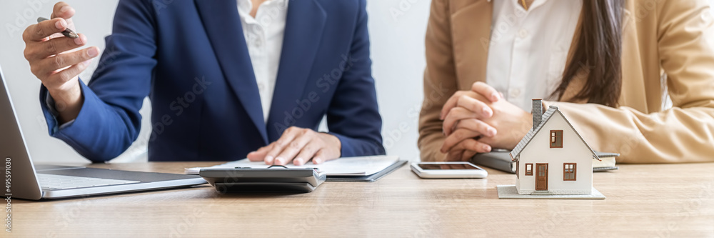 House model with agent and customer discussing for contract to buy, get insurance or loan real estate or property. House model with agent and customer discussing for contract to buy, get insurance or loan real estate or property.