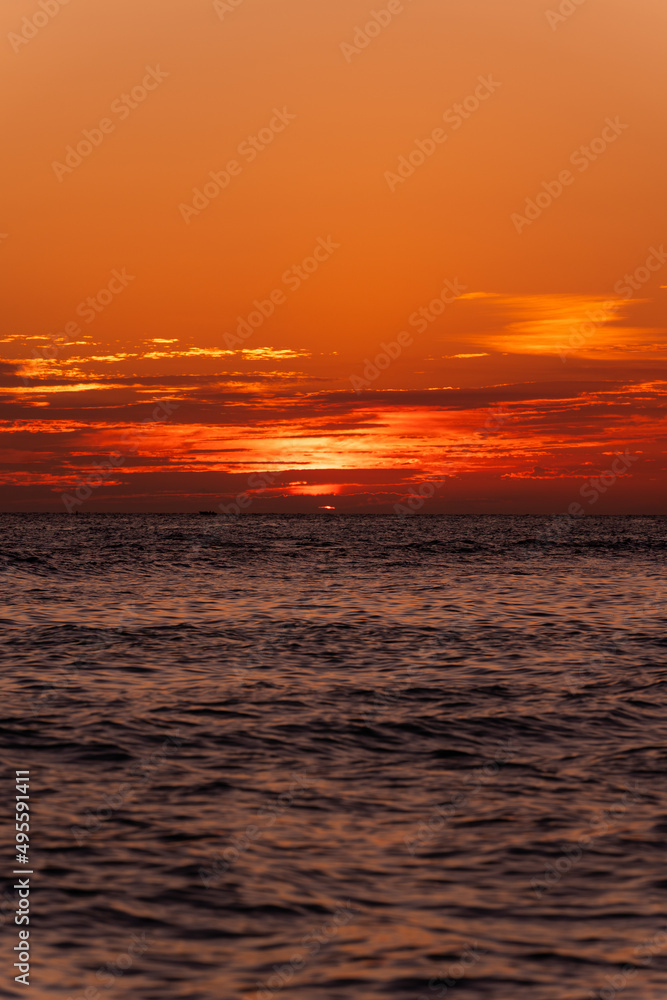 Incredibly beautiful best orange sunset or sunrise on the Caribbean Sea in the Dominican Republic. Sea, sky with clouds and horizon