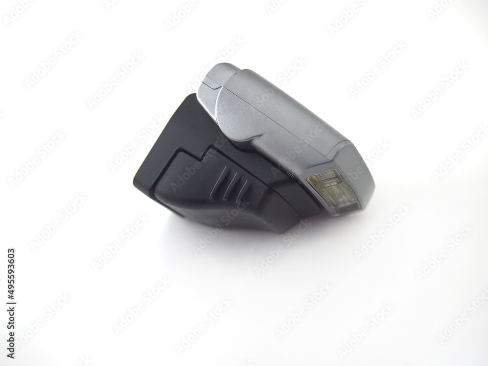Mirrorless camera external flash on a white background. View from the side.