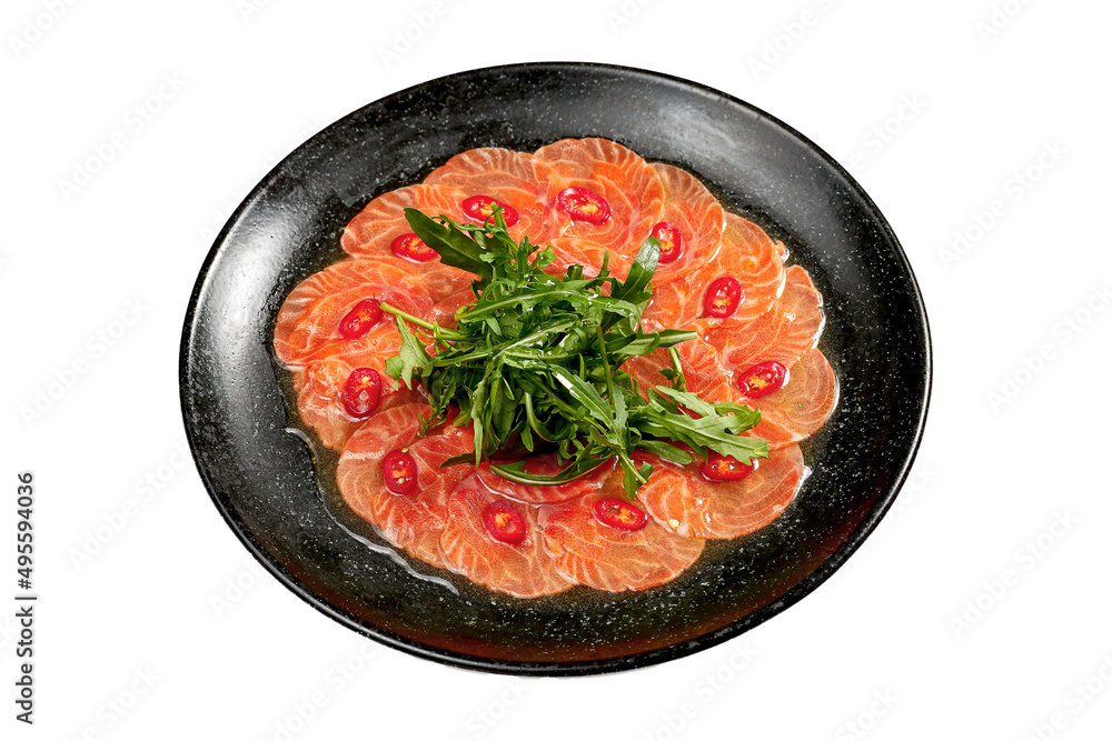 Salmon carpaccio with arugula on a white plate