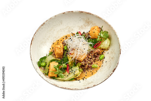 Fried tofu with quinoa and curry sauce in a bowl on a white background