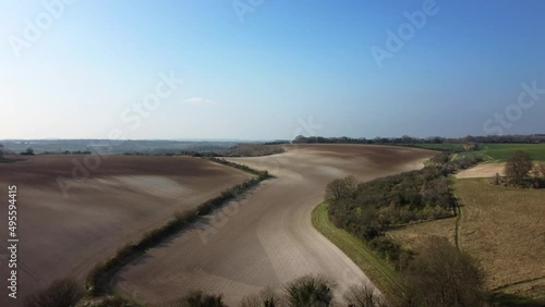 Drone shot flying over fields and farms in Hampshire, Britain on sunny day photo