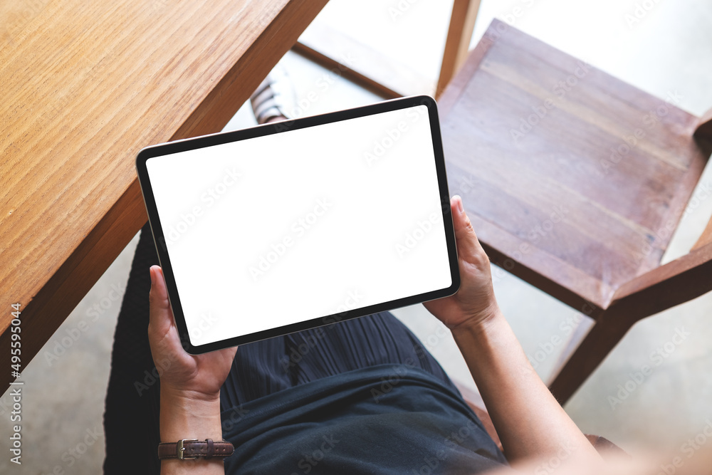 Top view mockup image of a woman holding digital tablet with blank white desktop screen in cafe Top view mockup image of a woman holding digital tablet with blank white desktop screen in cafe
