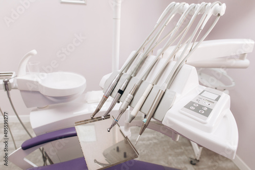 Modern dental practice. Dental chair and other accessories used by dentists in violet  copper light