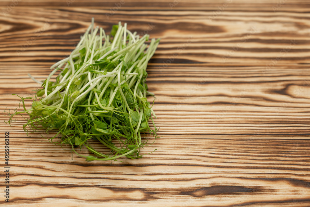 a bunch of freshly cut micro-green peas on a wooden tabletop, stylized by firing a bunch of freshly cut micro-green peas on a wooden tabletop, stylized by firing
