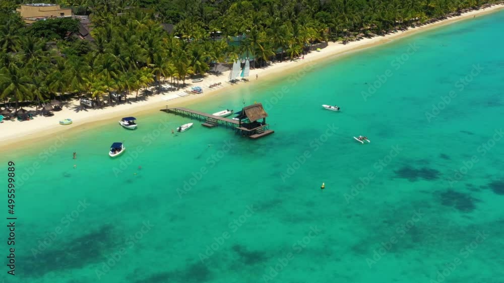 Glide above a sunny pier and crystal clear ocean at Trou aux Biches, Mauritius Glide above a sunny pier and crystal clear ocean at Trou aux Biches, Mauritius