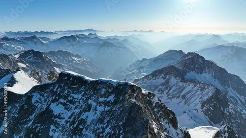 Drone shot of a person standing on a mountain in winter. Hochgall, Rieserfernergruppe. photo