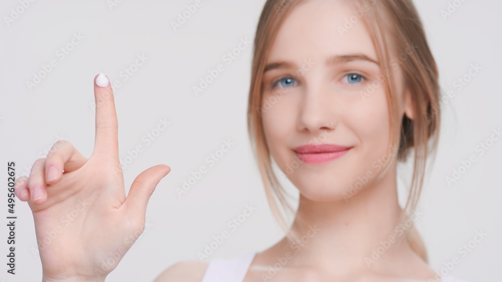 Young gorgeous beauty model shows a drop of cream on her finger. Demonstrates easiness of applying moisturizing cream | Skin care products advertising concept. Young gorgeous beauty model shows a drop of cream on her finger. Demonstrates easiness of applying moisturizing cream | Skin care products advertising concept.