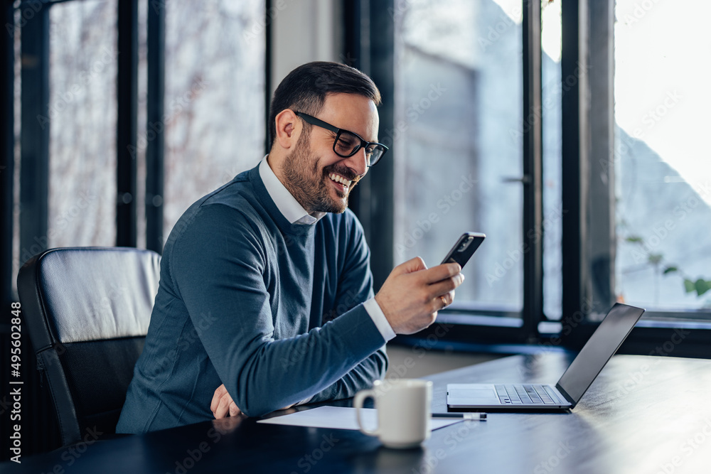 Smiling businessman, searching for something over the phone.