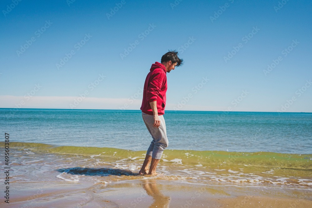Young man walking near the sea