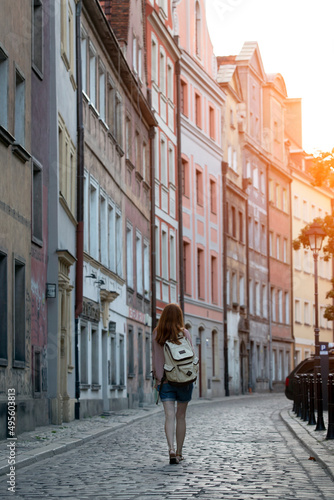 a girl walks through the streets of an old European city