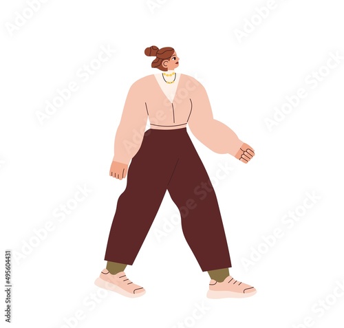 Young modern woman walking in casual fashion clothes, sneakers and pants outd...