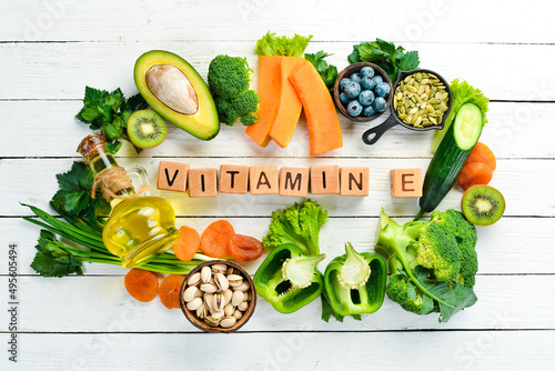 Foods rich in vitamin E: pumpkin, broccoli, dried apricots, parsley, avocado and vegetables. The inscription "Vitamin E". Top view.