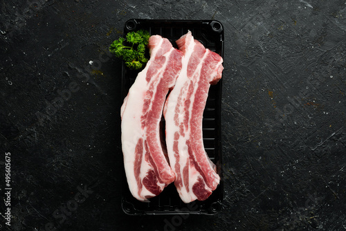 Pork. Raw fresh pork ribs on black slate stone background. Top view. Cooking.