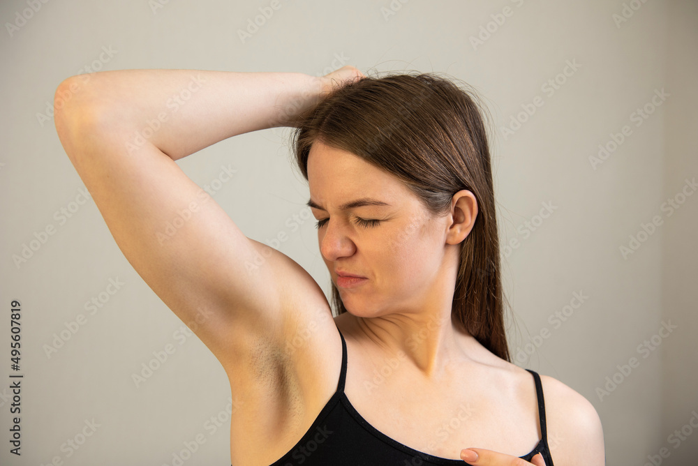 young female smells her armpit