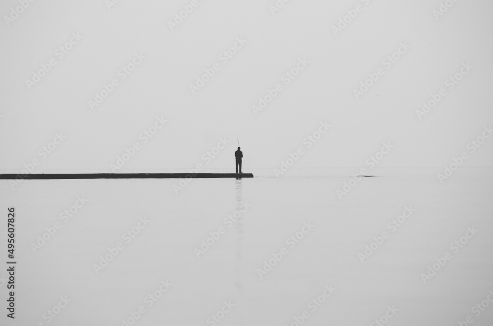 fisherman on the pier minimalism Odessa Ukraine fisherman on the pier minimalism Odessa Ukraine