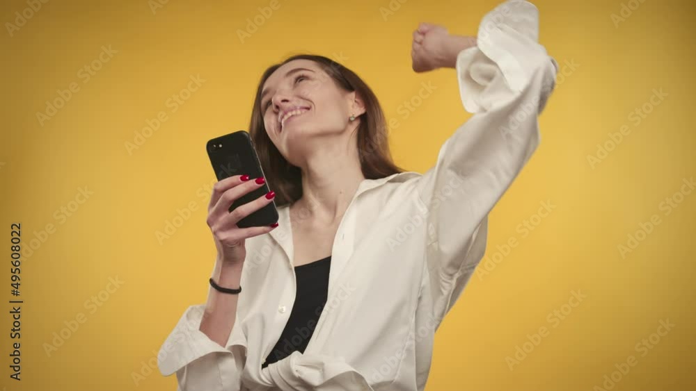 Young adult caucasian woman is passing exam on a bright yellow background Young adult caucasian woman is passing exam on a bright yellow background