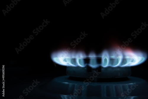 Gas burner with blue flame, glowing fire ring on kitchen stove.Concept of gas crisis. High prices of natural resources. Tongues of flame. Public debt. Energy war. Saving home budget.