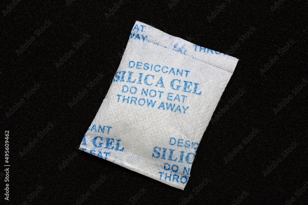 Silica gel in a package on black background. Silica gel used to protect products from moisture