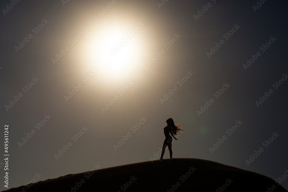Silueta a contraluz de chica sensual en verano sobre una duna de arena en la playa Silueta a contraluz de chica sensual en verano sobre una duna de arena en la playa
