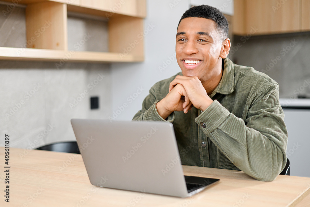 Concentrated latin businessman rested chin with both hands and looking away in front of the laptop display, solving business tasks, looking for new ideas Concentrated latin businessman rested chin with both hands and looking away in front of the laptop display, solving business tasks, looking for new ideas