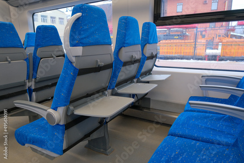 Chairs with folding tables in public transport. Seats in the commuter train.