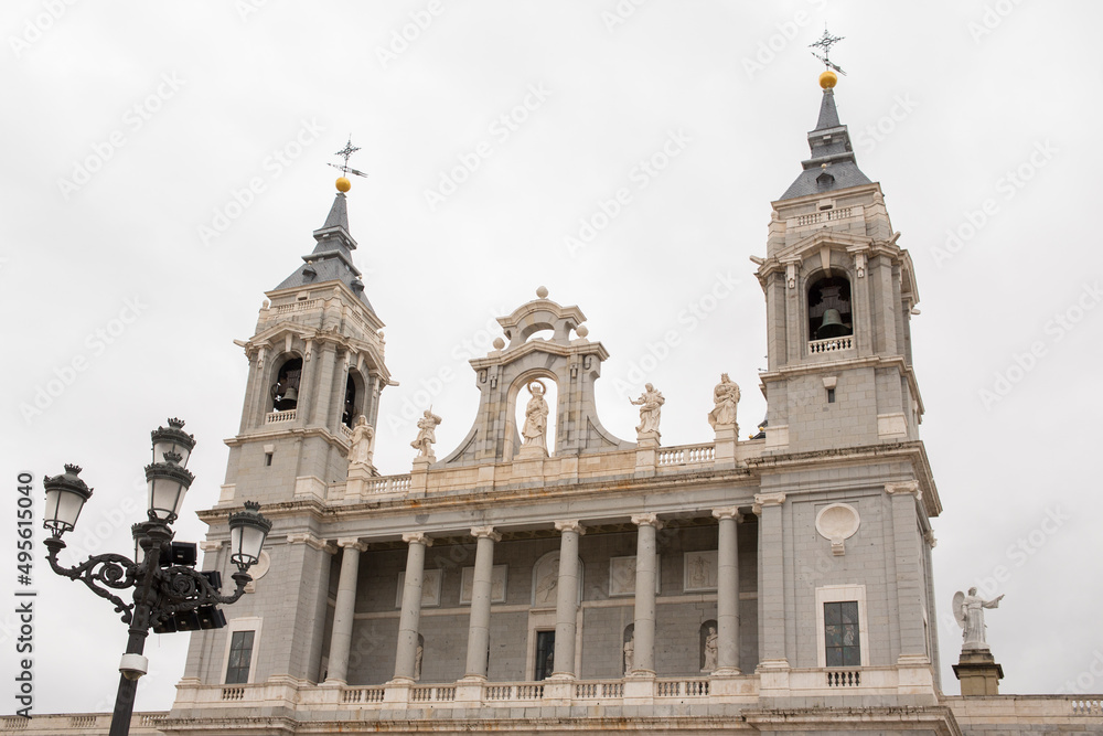 Main facade of Almudena Cathedral in Madrid, Spain. On the sides of the facade there are two bell towers. 