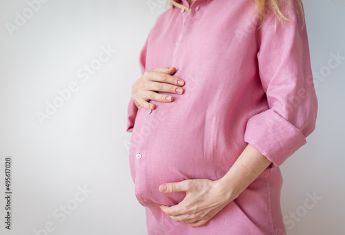 Wallpaper Mural a pregnant woman stands with her hands on her stomach, the concept of expecting a baby Torontodigital.ca