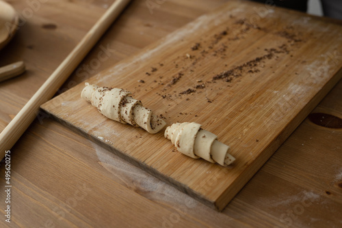 Dough with chocolate on a wooden board for making croissants.