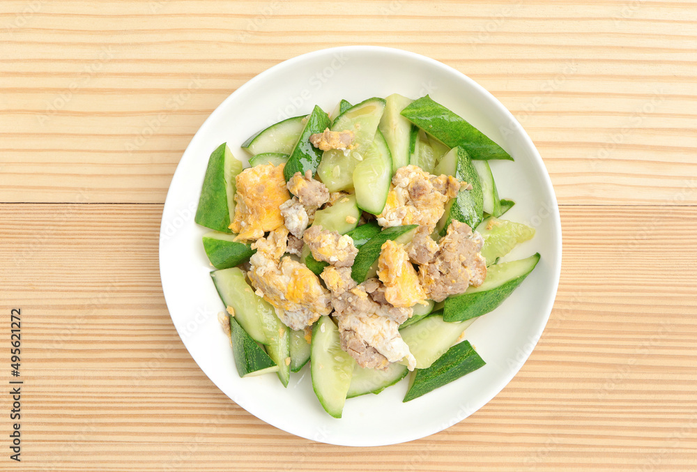 Asian stir-fried cucumber with minced pork, egg and oyster sauce in white plate. Asian food style. Asian stir-fried cucumber with minced pork, egg and oyster sauce in white plate. Asian food style.