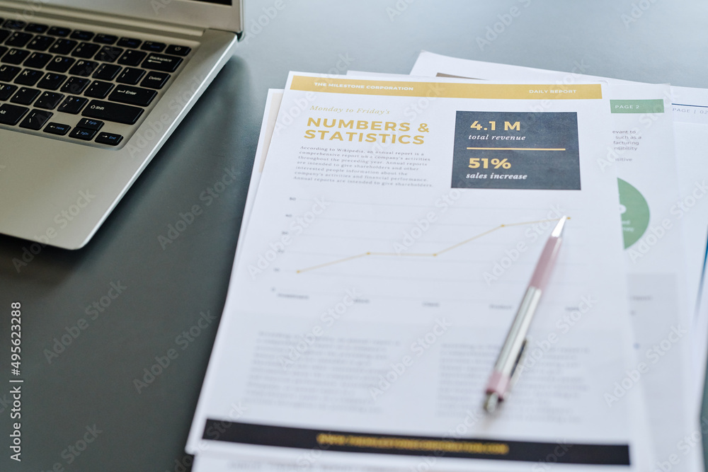 Several financial documents with data, pen and keyboard of laptop on workplace of contemporary analyst of financial information Several financial documents with data, pen and keyboard of laptop on workplace of contemporary analyst of financial information