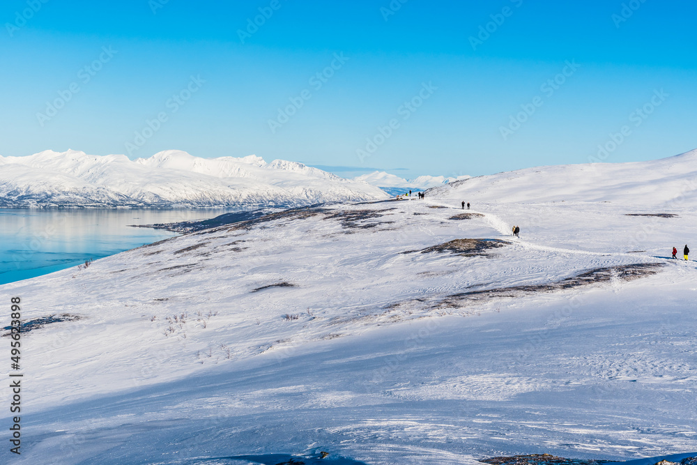 Tourists walking a hiking trail at the top of Storsteinen mountain in Tromso, Norway, copy space Tourists walking a hiking trail at the top of Storsteinen mountain in Tromso, Norway, copy space