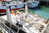 Drapeaux pour le repère des filets et casiers de pêche en mer rangés sur bateau dans un port.
