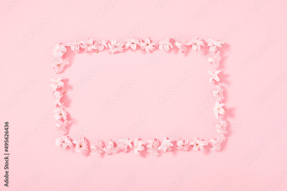 Minimal flowers composition, pattern of pink flowers on pink background. Spring background. Flat lay, top view, copy space Minimal flowers composition, pattern of pink flowers on pink background. Spring background. Flat lay, top view, copy space