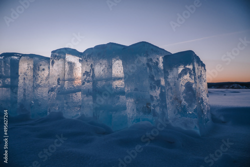 Sunset sky and ice on Lake Baikal. Winter ice on Lake Baikal. Crystal clear water. Ice floes and ice in shallow water.