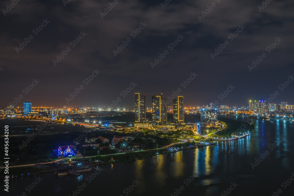 Aerial view of Bitexco Tower, buildings, roads, Thu Thiem 2 bridge and Saigon river in Ho Chi Minh city - Far away is Landmark 81 skyscrapper. This city is a popular tourist destination of Vietnam