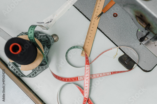 Designer work place with sewing machine, measuring tape and thread photo